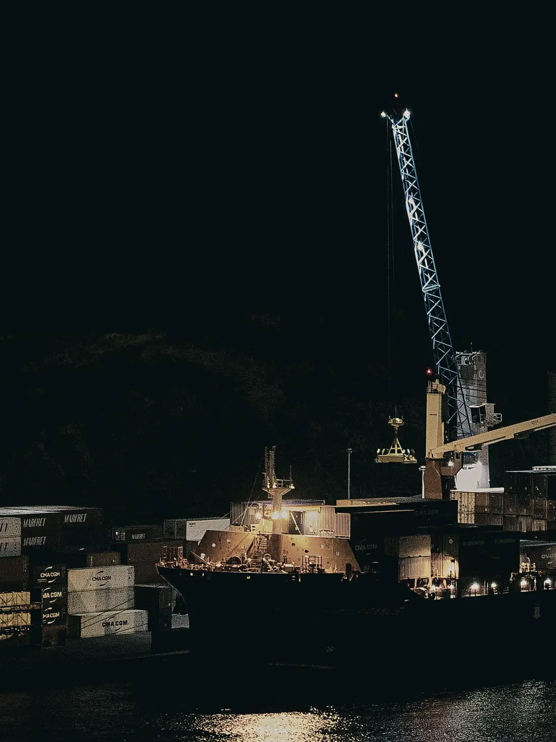 Container vessel loading at night (illustrative)